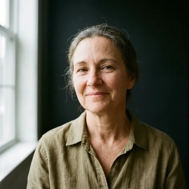 A middle-aged woman as an agent, in a linen shirt by a window: photorealistic portrait.